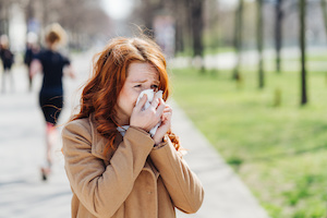 Ung kvinna som lider av pollenallergi